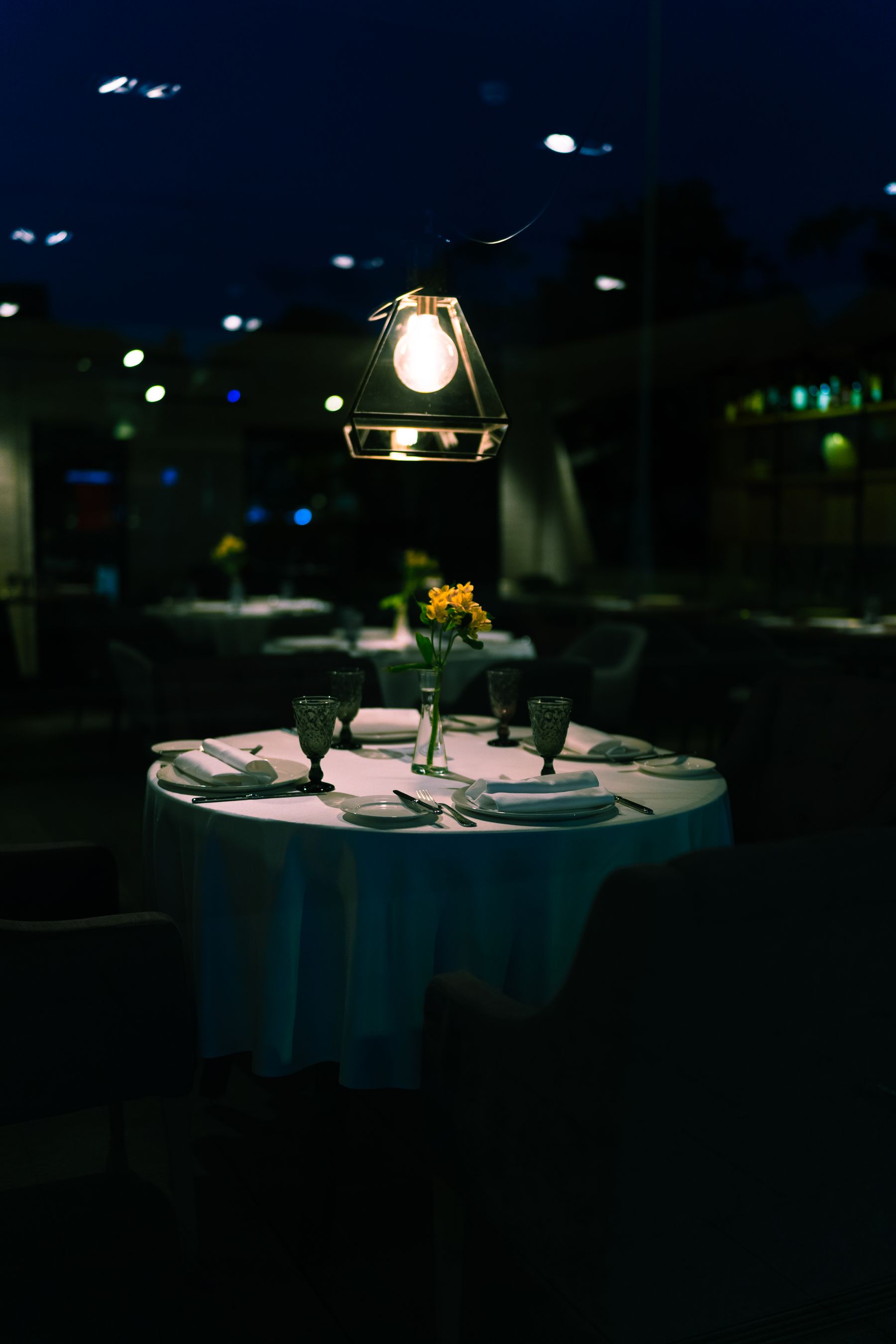 Wieczorna sala restauracji z nakrytymi stołami i ciepłym światłem